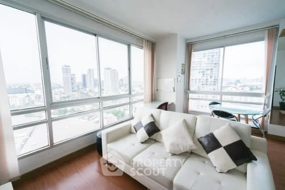 Bright living room with panoramic city views and modern white sofa.