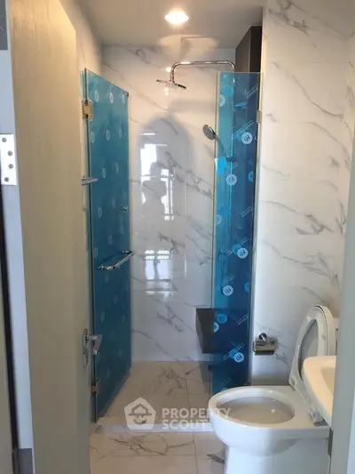 Modern bathroom with glass shower and marble tiles
