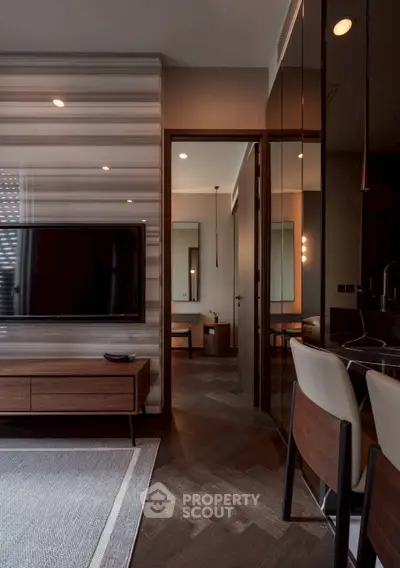 Modern living room with stylish decor and open view into adjacent room, featuring sleek furniture and ambient lighting.