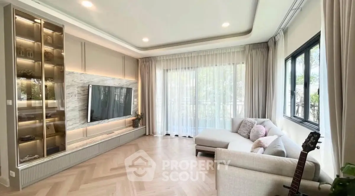 Spacious modern living room with large windows and elegant decor.