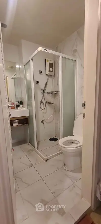 Modern bathroom with glass shower and white fixtures in a stylish apartment.