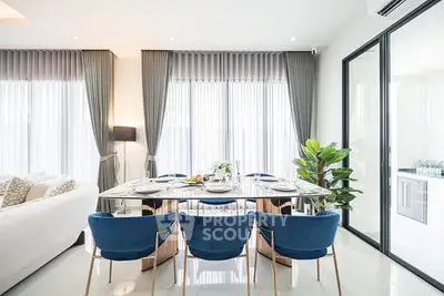 Luxurious modern dining room with elegant blue chairs and large windows, perfect for entertaining guests.