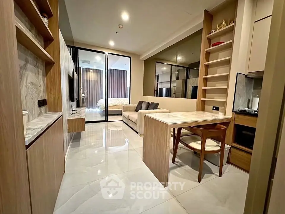 Modern open-plan living room with sleek furniture and marble accents in a stylish apartment.