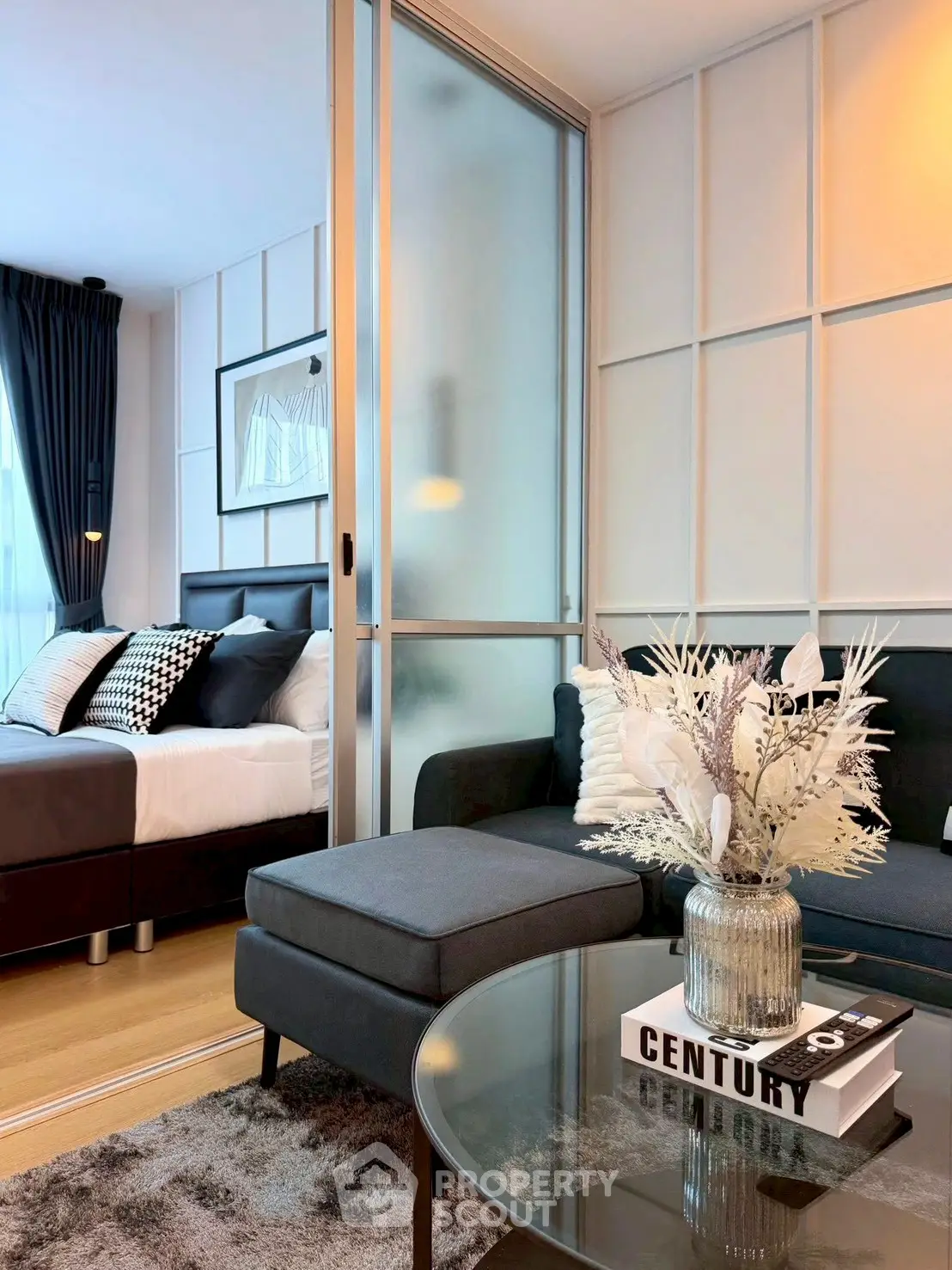 Modern living room with stylish decor and cozy bedroom view in open-plan apartment.