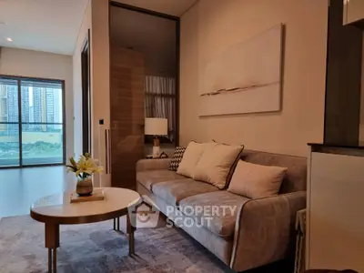 Elegant living room with plush sofa, modern decor, and ample natural light, perfect for urban living in a serene environment.
