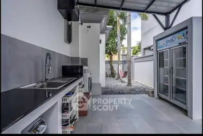 Modern outdoor kitchen with sleek countertops and spacious layout, perfect for entertaining in a stylish setting.