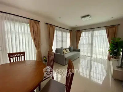 Spacious living room with elegant curtains and modern furniture, perfect for family gatherings.
