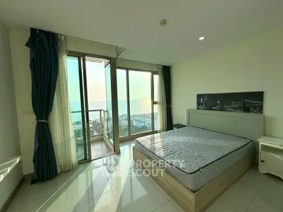 Spacious bedroom with stunning ocean view and private balcony access.