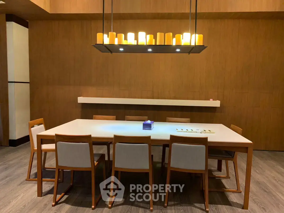 Elegant dining area with modern wooden table and chairs, featuring stylish overhead lighting.