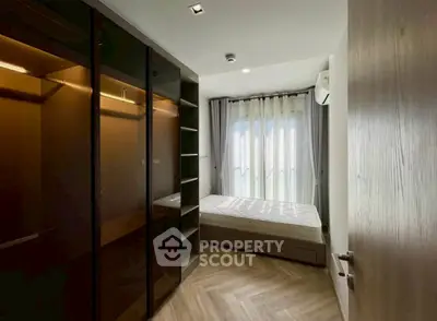 Modern bedroom with large wardrobe and natural light through sheer curtains.