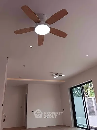 Modern interior with ceiling fan and large window, minimalistic design.