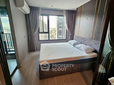 Modern bedroom with large window and city view, featuring stylish decor and ample natural light.