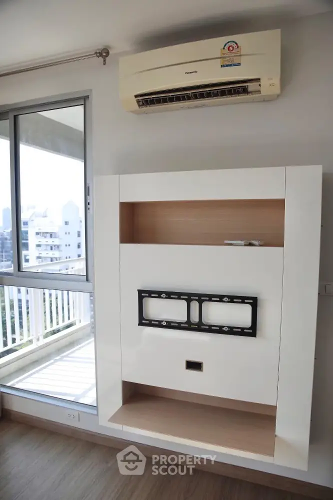 Modern apartment interior with air conditioning and TV mount near balcony