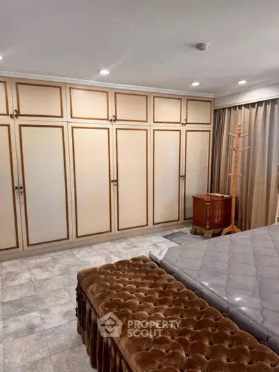 Luxurious bedroom with elegant built-in wardrobes and plush furnishings.