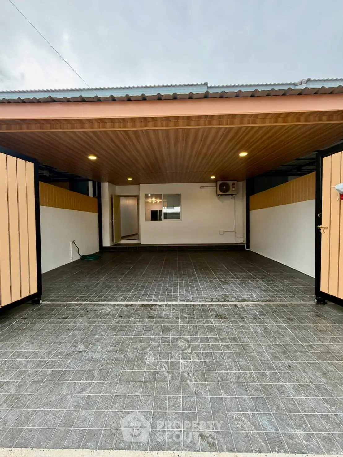 Spacious modern garage with tiled flooring and wooden ceiling, perfect for secure parking.