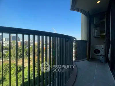 Spacious balcony with city view and laundry area in modern apartment.