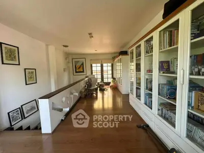 Spacious hallway with wooden flooring and built-in bookshelves, perfect for a cozy reading nook.