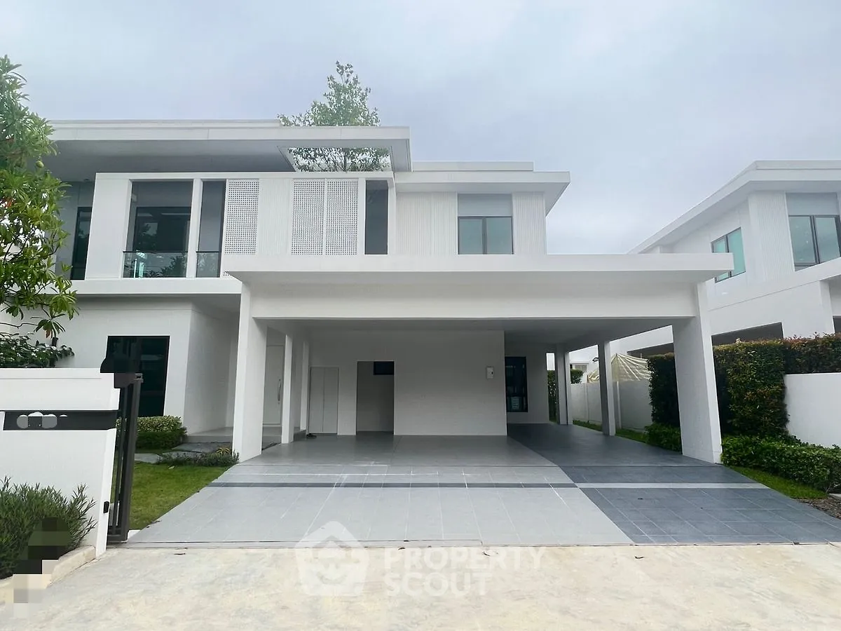 Modern two-story house with spacious driveway and sleek architectural design.