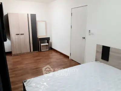 Spacious bedroom with modern wardrobe and wooden flooring