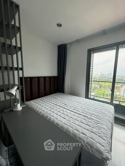 Modern bedroom with city view and sleek furnishings, featuring a cozy bed and stylish decor.