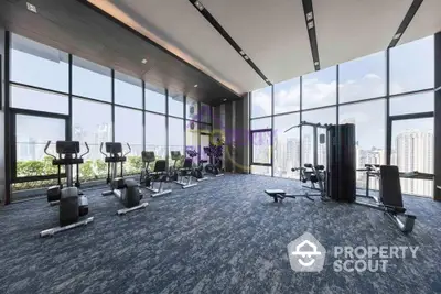 State-of-the-art gym with panoramic city views through floor-to-ceiling windows, modern equipment, and ample space for workouts.