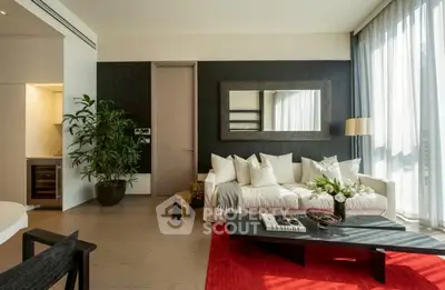 Luxurious living room with modern decor, large mirror, and vibrant red rug.