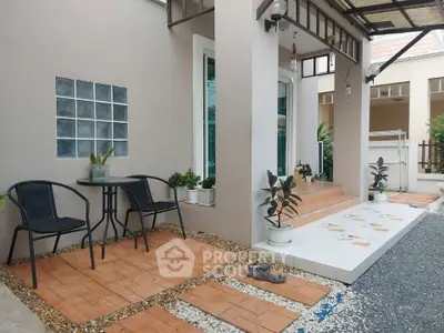 Charming modern home entrance with cozy outdoor seating and stylish landscaping.