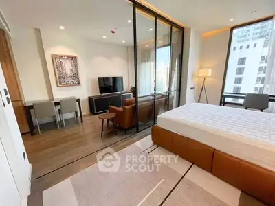 Modern studio apartment with glass partition, stylish furniture, and city view.