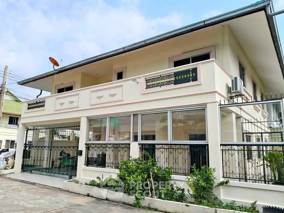 Elegant two-story house with modern balcony and lush greenery in a serene neighborhood.