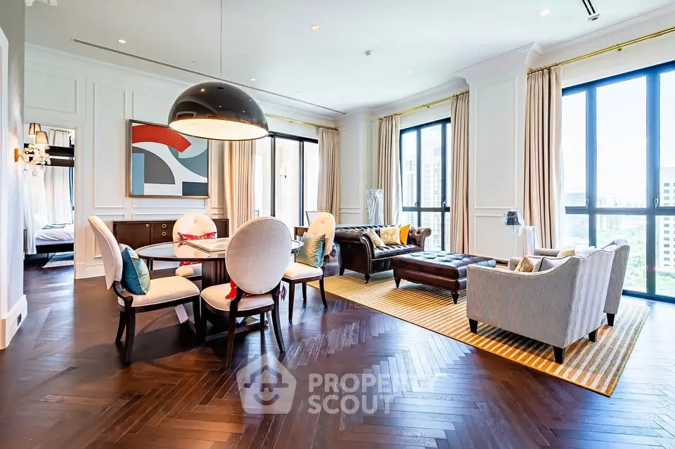 Luxurious living room with elegant decor and city view, featuring hardwood floors and stylish furniture.