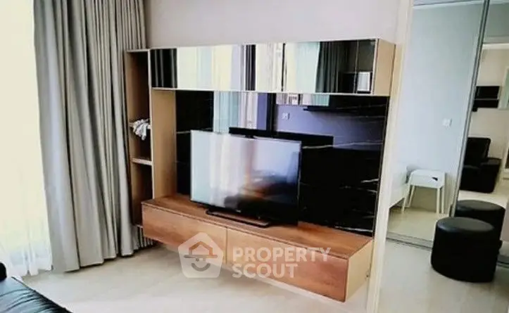 Modern living room with sleek TV unit and mirrored accents