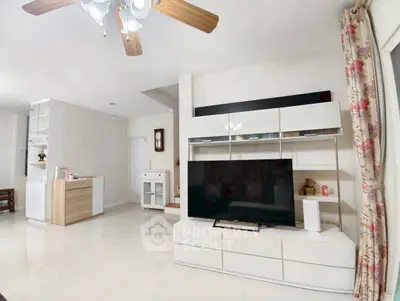 Spacious living room with modern entertainment center and ceiling fan