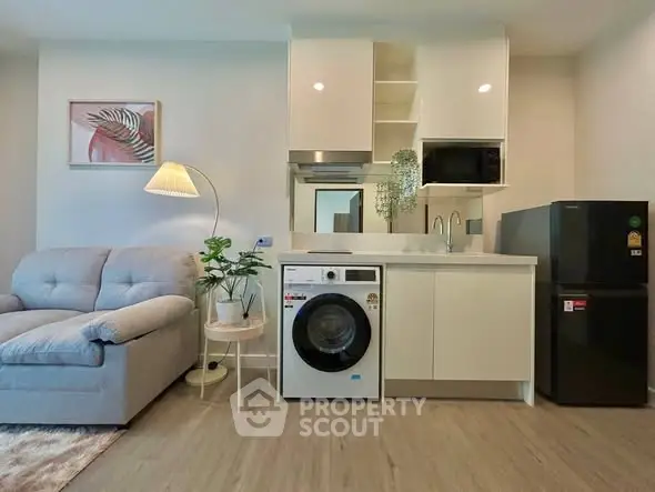 Modern living room with washing machine and compact kitchen setup