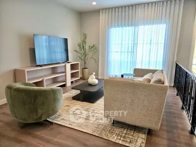 Modern living room with stylish furniture and large TV, perfect for relaxation.