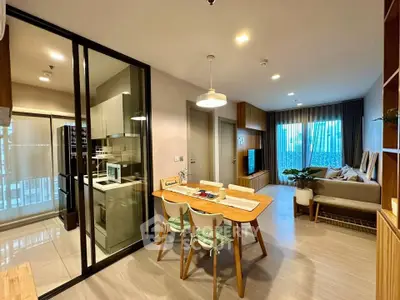 Modern open-plan living room and kitchen with stylish decor and natural light.