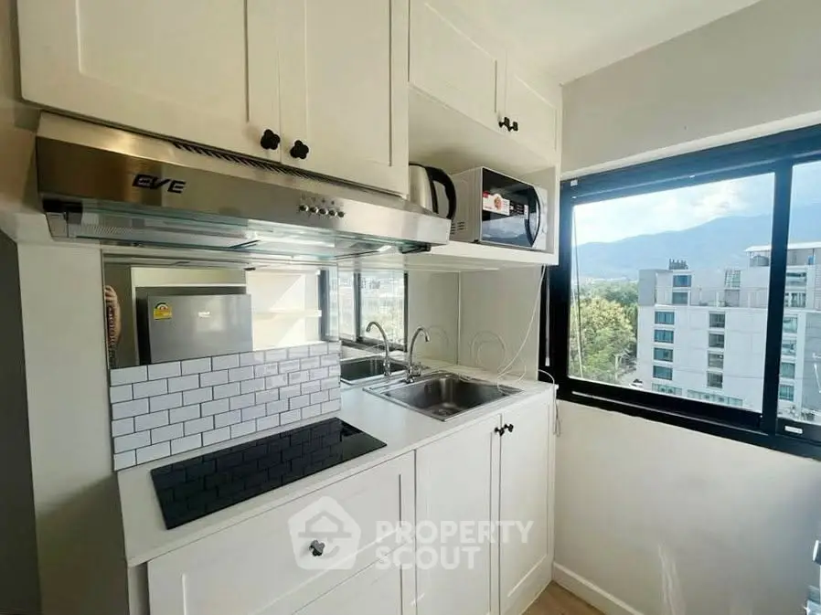 Modern kitchen with sleek cabinetry and scenic window view in urban apartment