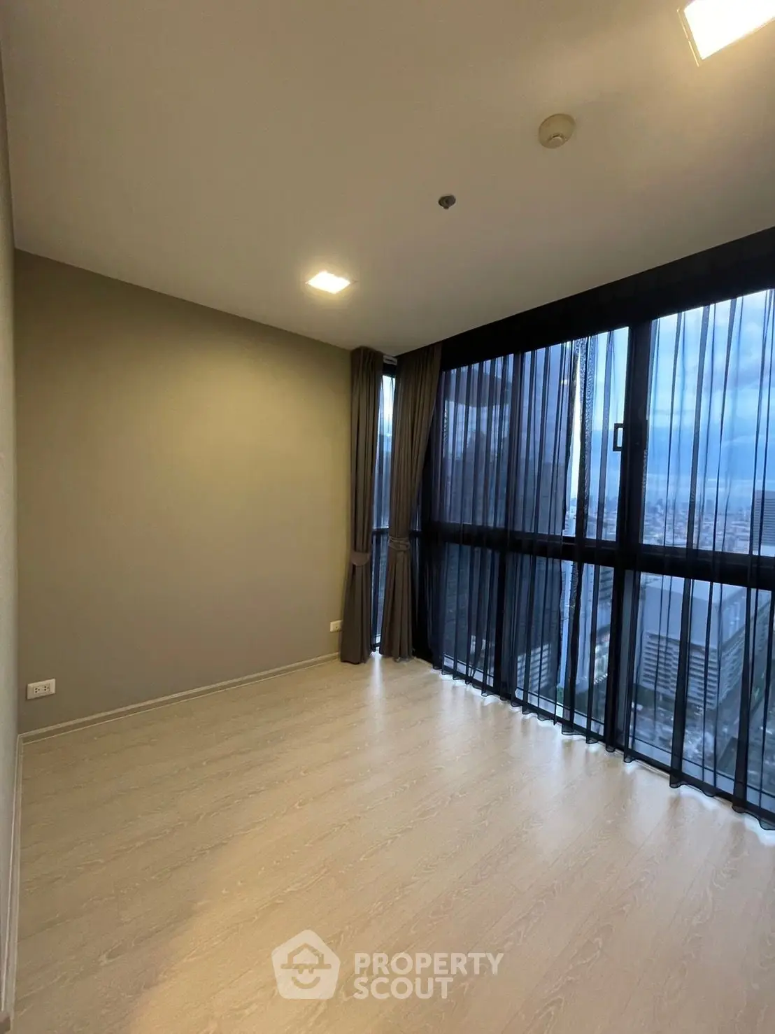 Spacious empty room with large windows offering stunning city views, perfect for customization.