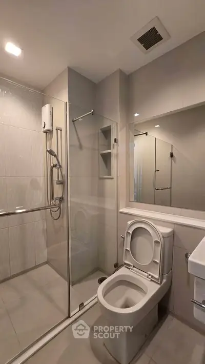 Modern bathroom with glass shower and sleek fixtures in a contemporary apartment.
