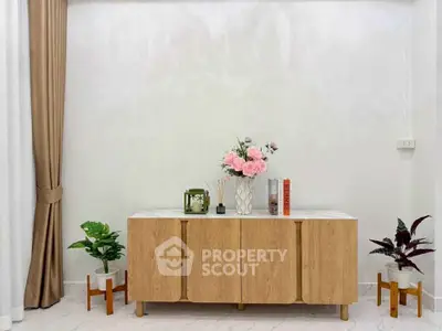 Elegant interior with modern wooden cabinet and decorative plants in a stylish living room setting.