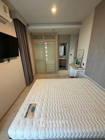 Modern bedroom with minimalist design and large window for natural light.