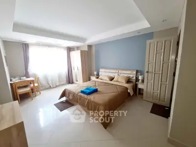 Spacious bedroom with modern decor and natural light in a stylish apartment.