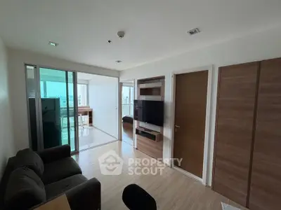 Modern living room with sliding glass doors leading to a bright balcony, featuring sleek wooden accents and a cozy sofa.