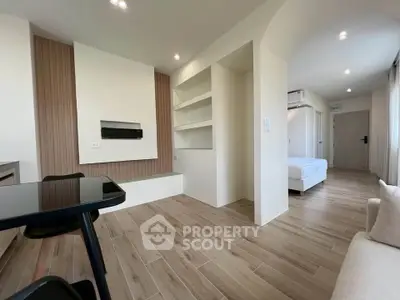 Modern open-plan living room with wooden flooring and built-in shelves