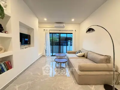 Modern living room with sleek marble flooring and cozy beige sofa, featuring a stylish floor lamp and built-in shelving.
