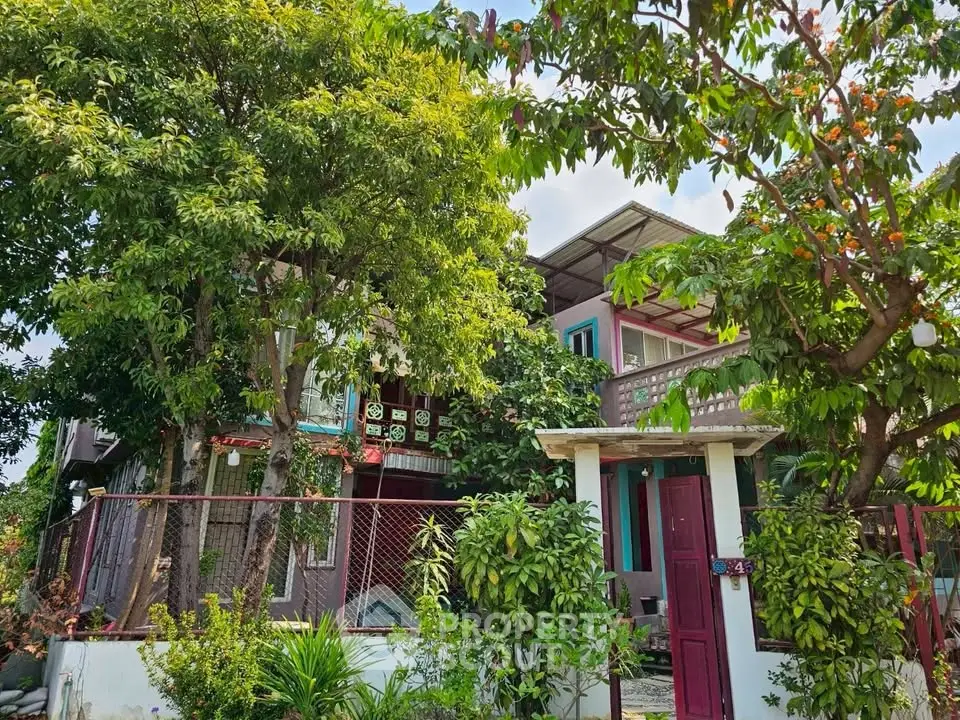 Charming two-story house with lush garden and vibrant exterior in a serene neighborhood.