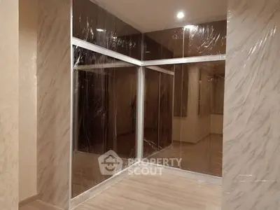 Modern interior with glass walls and wood flooring, perfect for a stylish home or office space.