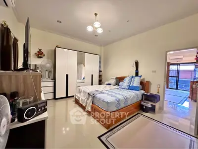 Spacious bedroom with modern decor and ample storage in a well-lit home.