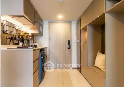 Modern kitchen with sleek cabinetry and integrated washing machine in compact apartment.