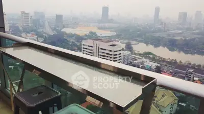 Stunning cityscape view from a high-rise balcony with sleek railing and seating area.