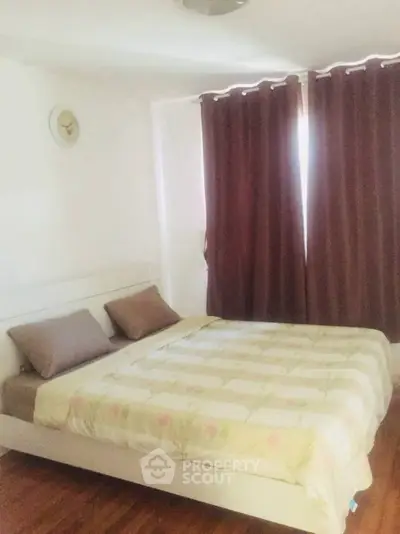 Cozy bedroom with large bed and dark curtains, perfect for restful nights.
